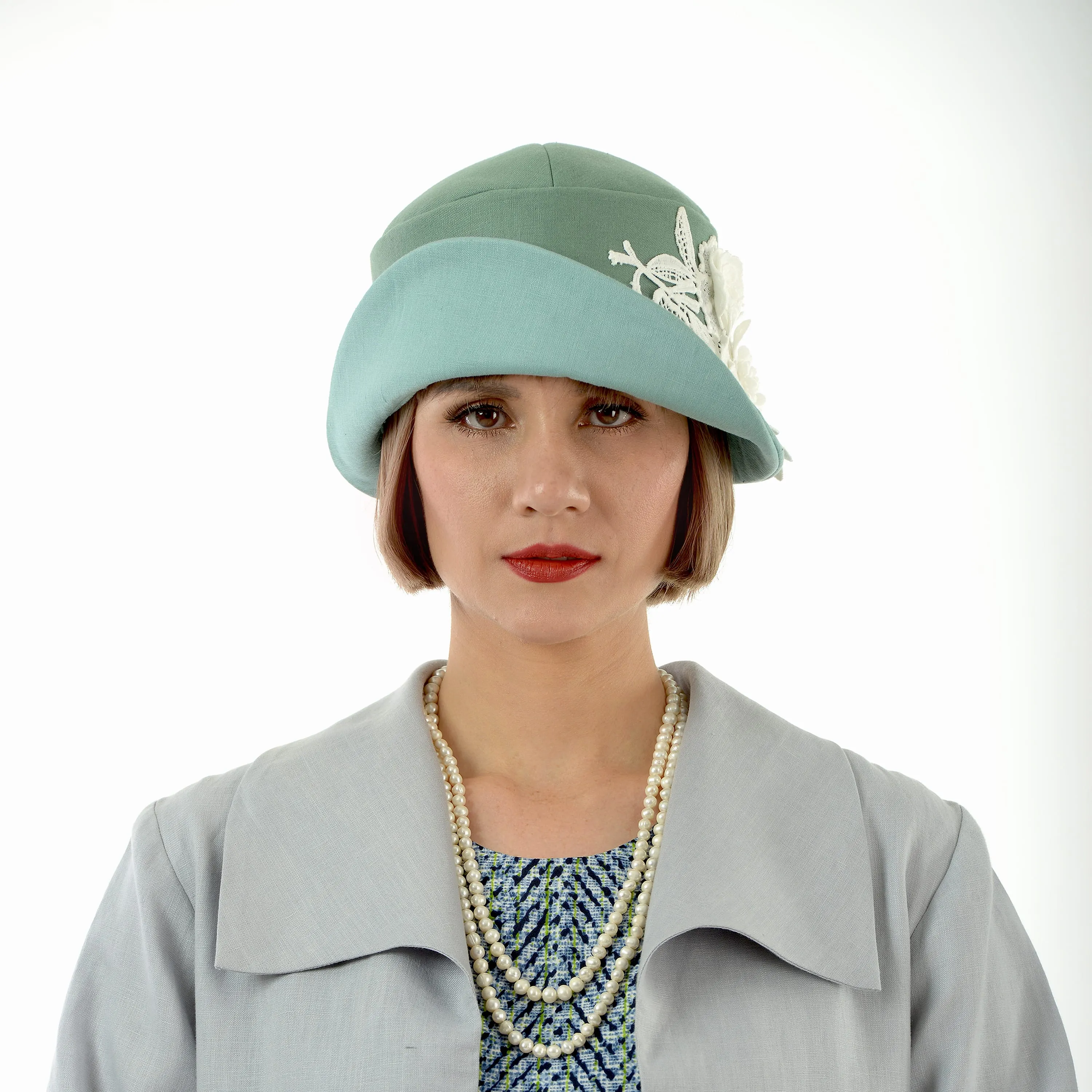 1920s-inspired linen cloche hat in muted green and pastel blue